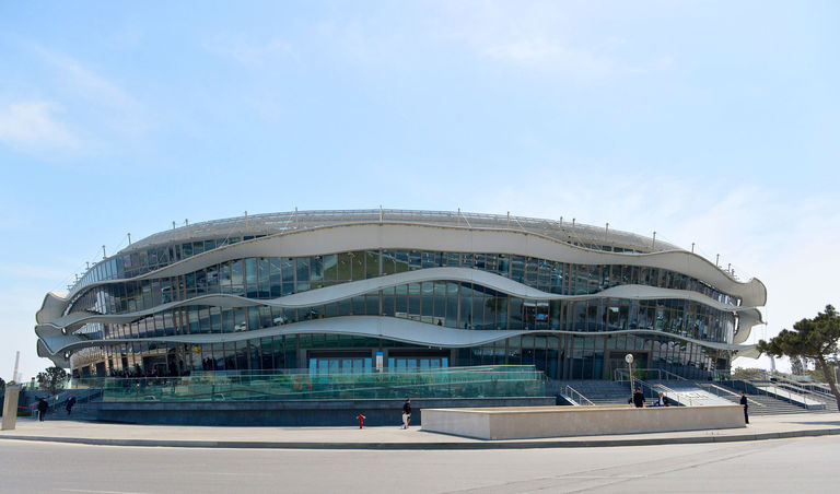 Exterior façade photo of National Gymnastics Arena in Baku, Azerbaijan, the three ribbon-like louvres wrapping around the building controlling daylight and solar gain.