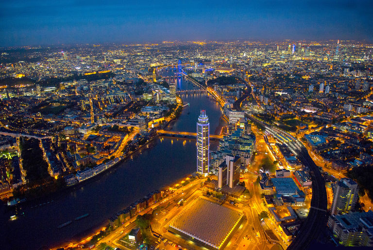 Aerial photo of London at night, featuring The Tower, One St George Wharf and Nine Elms regeneration area in the foreground.