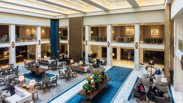 Hotel lobby at Tivoli Avenida Liberdade, refurbished with the historic glamour of gold screens and blue velvets.