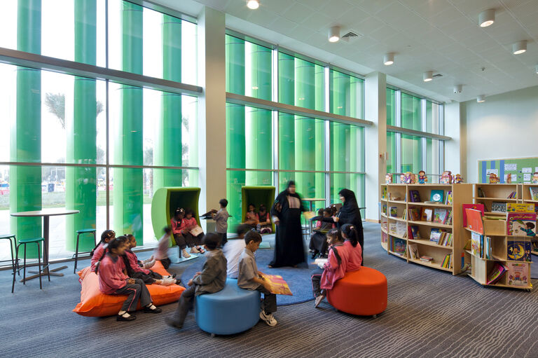 Green vertical louvres controlling heat gain and daylight to library at Mubarak Bin Mohammed School in Abu Dhabi.
