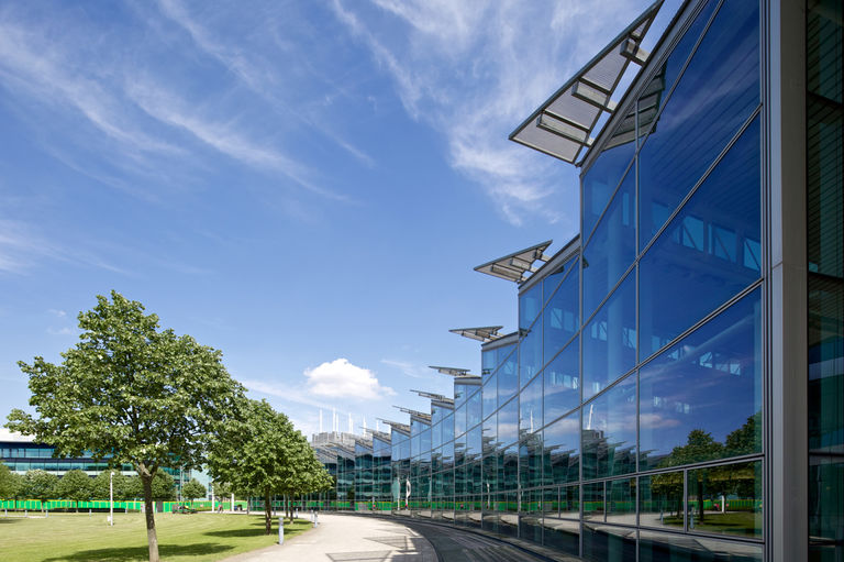 The Link building at BP's International Centre for Business and Technology, featuring a curving glass facade and saw-tooth roof clad in photovoltaic panels.