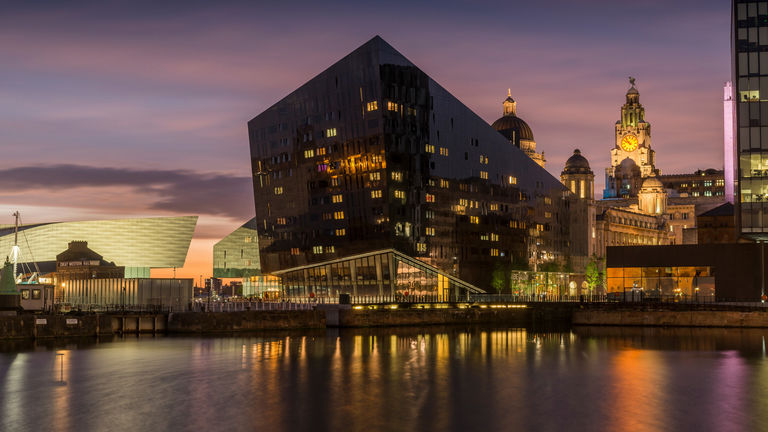 Evening photo of Mann Island complex in Liverpool, with covered glazed winter garden and RIBA North sitting within the central block.