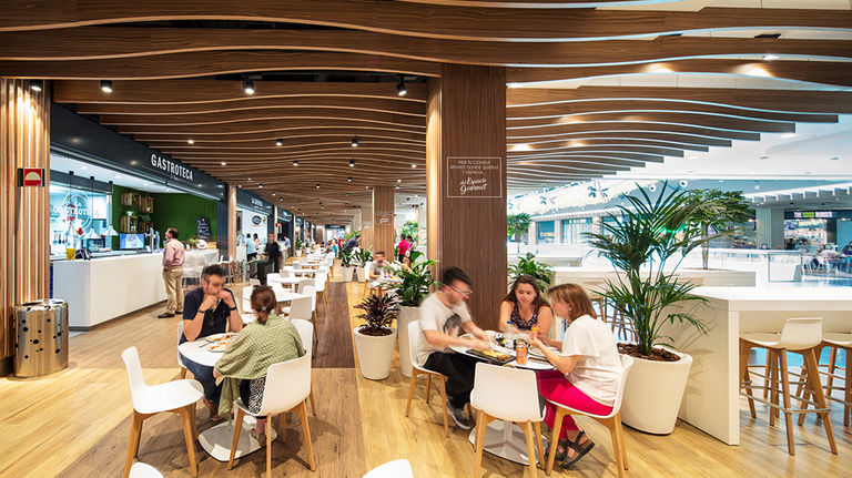 Interior photo of new timber finishes and contemporary furniture in the food court of El Tiro, a retail mall in Murcia, Spain.